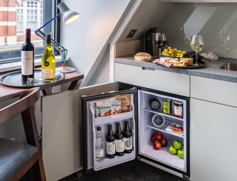 A miniature kitchen area with a built in fridge, in Covent Garden.