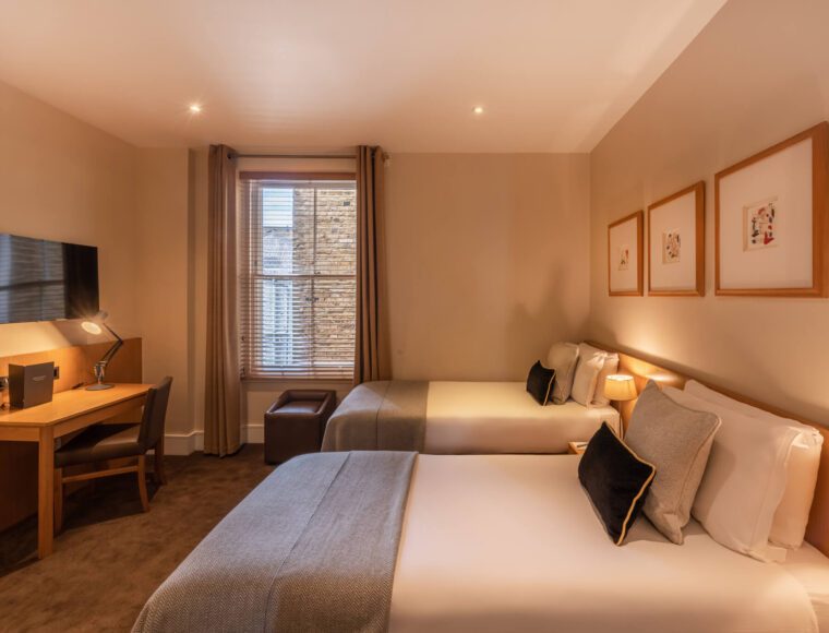 A kingsize twin room with a desk, two single beds and television, located in Kensington.