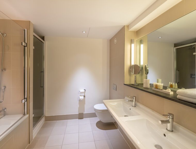 A large bathroom with a shower, bathtub and two sinks, located in Liverpool.