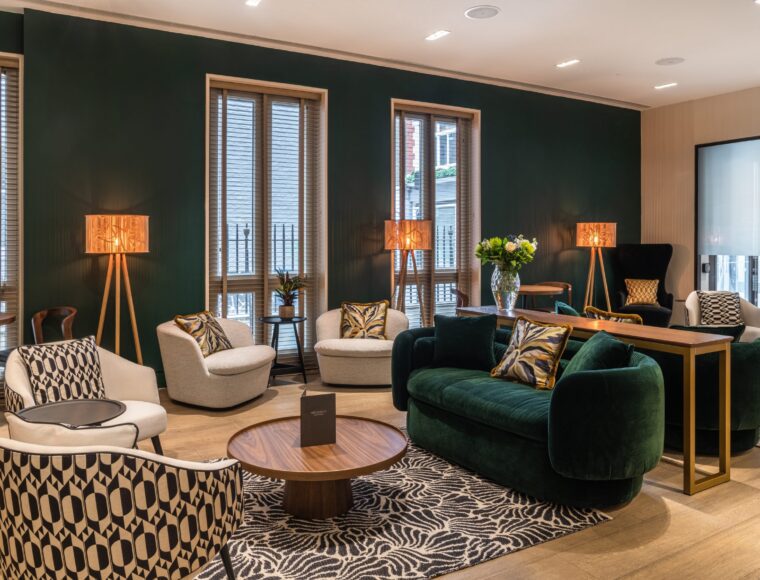 Hotel lounge with multiple sofas, coffee tables and lamps, located in Soho.