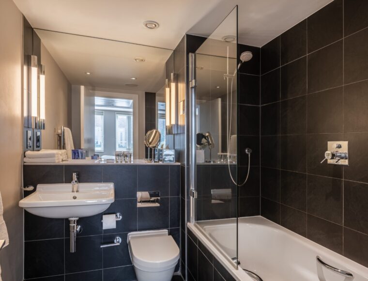 A small bathroom with a built-in bathtub and shower.