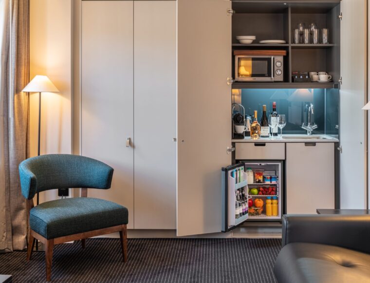 A built in miniature kitchen area with a fridge and microwave, located in Soho.