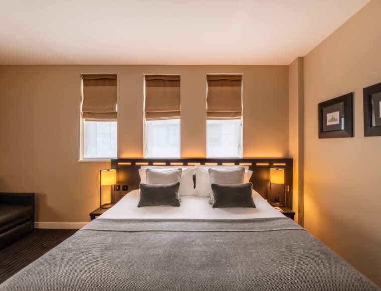 A deluxe room, with a double bed and sofa, located in Victoria.