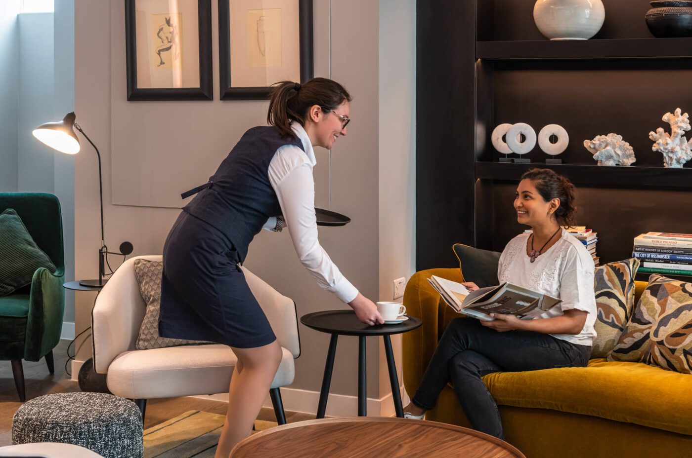 Hotel Professional providing a customer with a hot beverage.