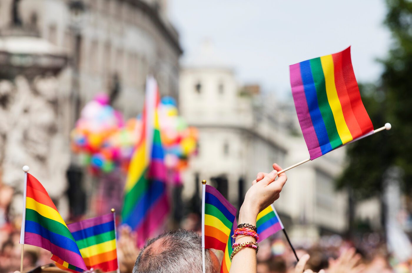 A spectator waves a gay rainbow flag at an LGBT gay pride march in London