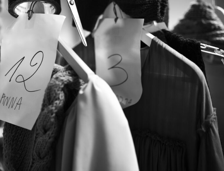 Backstage of a fashion show, clothes hanging in the wardrobe